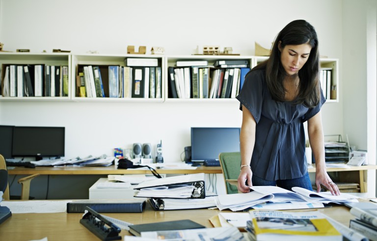 Female architect examining documents at desk. Creative image #: 107670162 License type: Rights-managed Photographer: Thomas Barwick / Getty Images