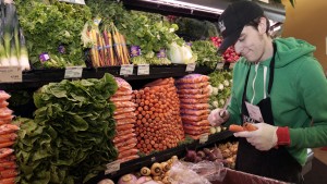 Whole Foods grocery store worker Tim Owen trims the tops of organic carrots in the produce section of the store in Ann Arbor, Michigan, March 8, 2012. Photo by Rebecca Cook/Reuters