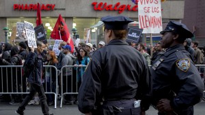 New York City Police officers (NYPD) watch as demonstrators calling for social, economic and racial justice march in New York