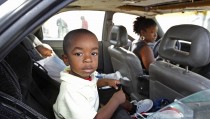 Debbie Summers (R) sits at the wheel of her car with all of their possessions inside as her children, Jordain (C), 3, and Jomari, 2, sit in the back seat as they wait for admittance to a homeless shelter at the offices of Faith in Action community housing in Fort Lauderdale, Florida, December 21, 2011. In a report issued earlier this month, the National Center on Family Homelessness, based in Needham, Massachusetts, said 1.6 million children were living on the streets of the United States last year or in shelters, motels and doubled-up with other families. That marked a 38 percent jump in child homelessness since 2007 and Ellen Bassuk, the center's president, attributes the increase to fallout from the U.S. recession and a surge in the number of extremely poor households headed by women. Picture taken December21, 2011. TO MATCH FEATURE USA-HOMELESS/ REUTERS/Joe Skipper (UNITED STATES - Tags: SOCIETY) - RTR2VLFU