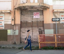 A woman walks past a closed restaurant in Ponce, on Puerto Rico's southern coast, February 5, 2014. Standard & Poor's cut Puerto Rico's credit rating to junk status, in the latest blow to an economy that has been battling chronic recession, population decline and a perennial budget shortfall that has left it with $70 billion in debt. REUTERS/Alvin Baez (PUERTO RICO - Tags: BUSINESS POLITICS) - RTX189FA