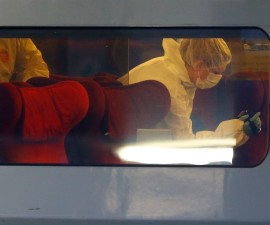 French investigating police in protective clothing films inside the Thalys high-speed train where shots were fired in Arras, France, August 21, 2015. Three people were wounded in a shooting incident on high-speed train between Amsterdam and Paris on Friday, the French Interior Ministry said. A man was arrested when the train stopped at Arras station in northern France but his motives were not yet known, a ministry spokesman said.  REUTERS/Pascal Rossignol - RTX1P4TU