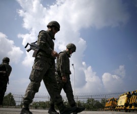 South Korean soldiers walk by barricades at a checkpoint on the Grand Unification Bridge which leads to the truce village Panmunjom, just south of the demilitarized zone separating the two Koreas, in Paju, South Korea, August 22, 2015. South Korea stands ready to respond to further provocations from North Korea, the presidential Blue House said on Saturday, as an ultimatum loomed for Seoul to halt anti-Pyongyang propaganda broadcasts by late afternoon or face military action.   REUTERS/Kim Hong-Ji - RTX1P5HM