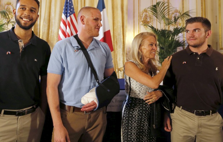 U.S. ambassador to France Jane Hartley (C) presents student Anthony Sadler, U.S Airman First Class Spencer Stone and National Guardsman Alek Skarlatos (L to R) as they attend a ceremony at the U.S. Embassy in Paris, France, August 23, 2015. The three men helped overpower a Kalashnikov-toting attacker on a high speed train heading for Paris from Amsterdam on Friday.   REUTERS/Regis Duvignau - RTX1PBY3