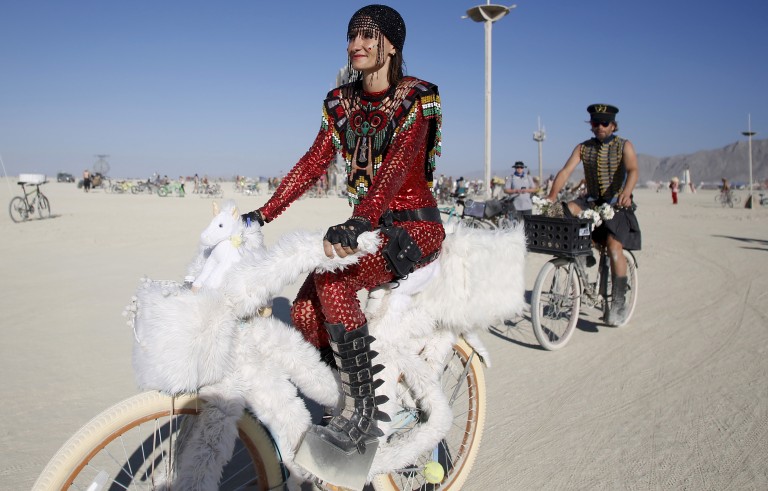 Bibi rides her unicorn-themed bike on the playa during the Burning Man 2015 "Carnival of Mirrors" in the Black Rock Desert of Nevada on Aug. 31. Approximately 70,000 people from all over the world are gathering at the sold-out festival to spend a week in the remote desert to experience art, music and the unique community that develops. Photo by Jim Urquhart/Reuters