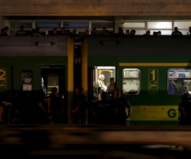 Police guard a train full of refugees stuck in a stalemate as they refuse to obey police and get off at the station, fearing they would be put up in a nearby refugee camp in Bicske, Hungary, September 3, 2015. France and Germany said European countries must be required to accept their shares of refugees, proposing what would potentially be the biggest change to the continent's asylum rules since World War Two. Europe's worst refugee crisis since the Yugoslav wars of the 1990s has strained the European Union's asylum system to breaking point, dividing its 28 nations and feeding the rise of right-wing populists. REUTERS/Laszlo Balogh - RTX1QZCZ