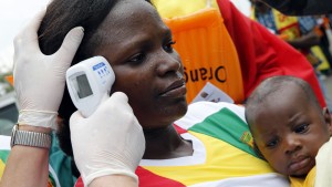 A health worker checks the temperature of a fan of Guinea at Malabo Stadium, ahead of their Group D soccer match against Ivory Coast in the African Cup of Nations, in Malabo January 20, 2015.  REUTERS/Amr Abdallah Dalsh (EQUATORIAL GUINEA - Tags: SPORT SOCCER HEALTH) - RTR4M6XG