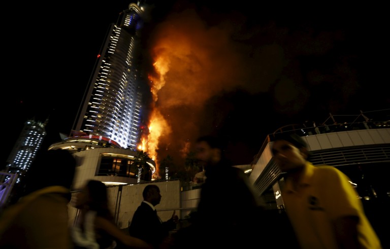 People run away after the burning The Address Hotel in downtown Dubai in the United Arab Emirates on Dec. 31, 2015. Photo by Ahmed Jadallah