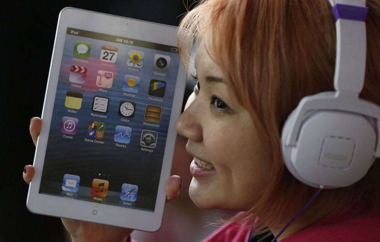 A woman holds a mock model of Apple's new iPad mini as she waits for the release of the tablet in front of the Apple Store Ginza in Tokyo November 1, 2012. This month, Apple entered the small-tablet market with its iPad mini, lagging Amazon.com Inc and Google Inc despite pioneering the tablet market in 2010.   REUTERS/Toru Hanai (JAPAN - Tags: BUSINESS) - RTR39UQT