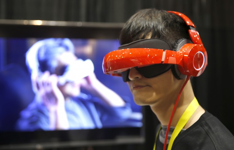 Eric Yu of Royole models the company's foldable Smart Mobile Theater system during "CES Unveiled," a preview event of the 2016 International CES trade show, in Las Vegas, Nevada January 4, 2016. The $700.00 system has noise-canceling headphones and a viewing system that is vision correctable so you don't need to wear your glasses, Yu said.  REUTERS/Steve Marcus - RTX2121Z