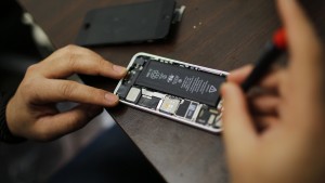 A worker tries to repair an iPhone in a repair store in New York, February 17, 2016. A court order demanding that Apple Inc help the U.S. government unlock the encrypted iPhone of one of the San Bernardino shooters opens a new chapter in the legal, political and technological fight pitting law enforcement against civil liberties advocates and major tech companies. REUTERS/Eduardo Munoz - RTX27FN5