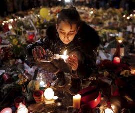 A girl lights candles as people pay tribute to the victims of Tuesday's bomb attacks, at the Place de la Bourse in Brussels, Belgium, March 26, 2016. REUTERS/Christian Hartmann TPX IMAGES OF THE DAY - RTSCCP0