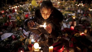 A girl lights candles as people pay tribute to the victims of Tuesday's bomb attacks, at the Place de la Bourse in Brussels, Belgium, March 26, 2016. REUTERS/Christian Hartmann TPX IMAGES OF THE DAY - RTSCCP0