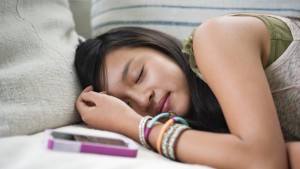 Teenage girl (13-14) asleep on sofa