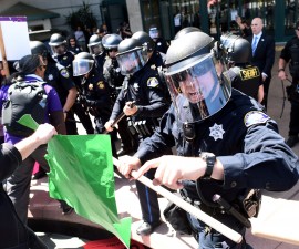 Police in riot gear hold back demonstrators against U.S. Republican presidential candidate Donald Trump outside the Hyatt hotel where Trump is set to speak at the California GOP convention in Burlingame, California, U.S., April 29, 2016. REUTERS/Noah Berger - RTX2C7BU