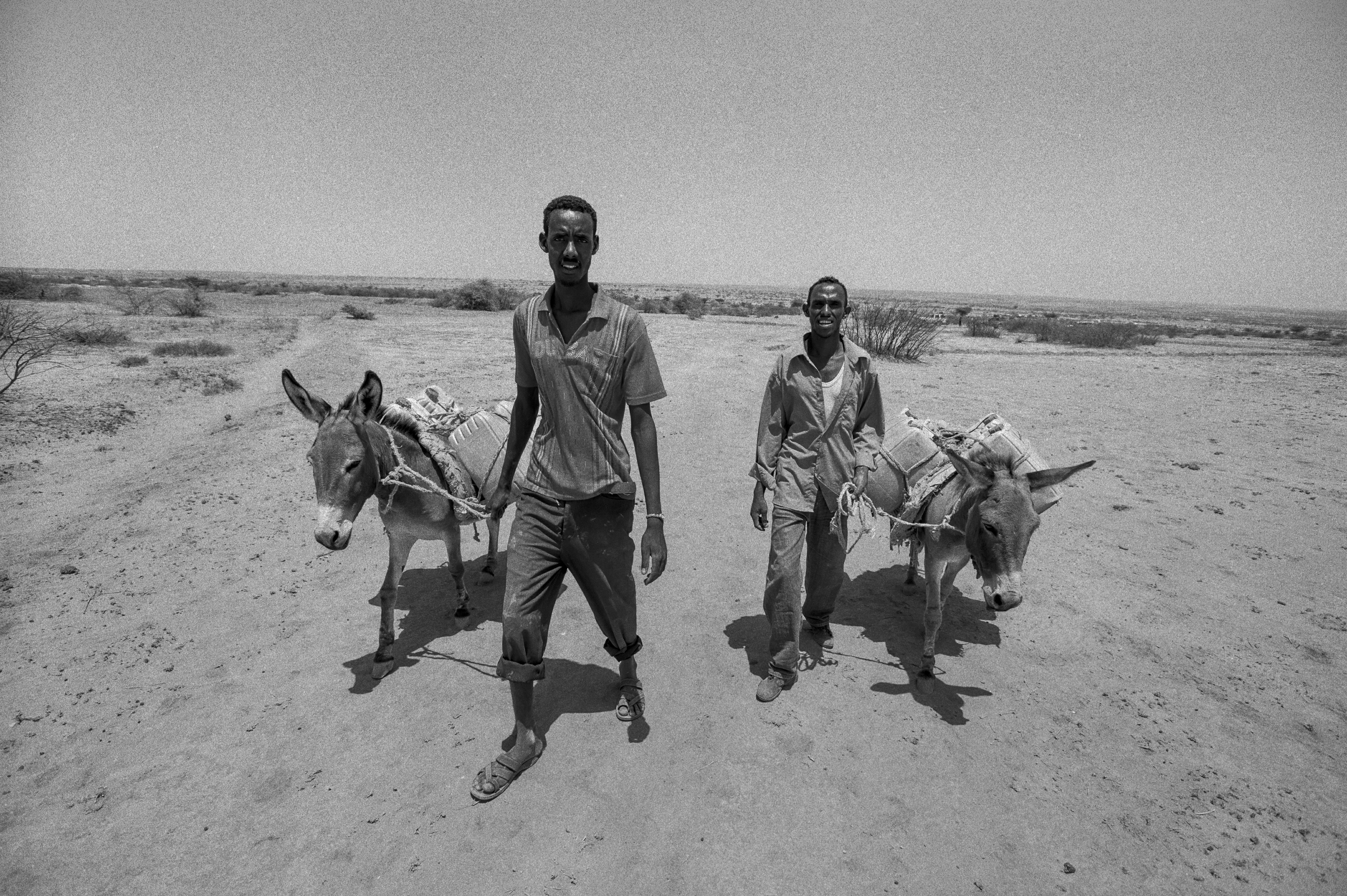Two young men return to their village after traveling 25 miles to hunt for water. Photo by Sebastian Rich for UNICEF