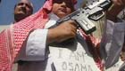 man with gun with 'i am osama' on his chest