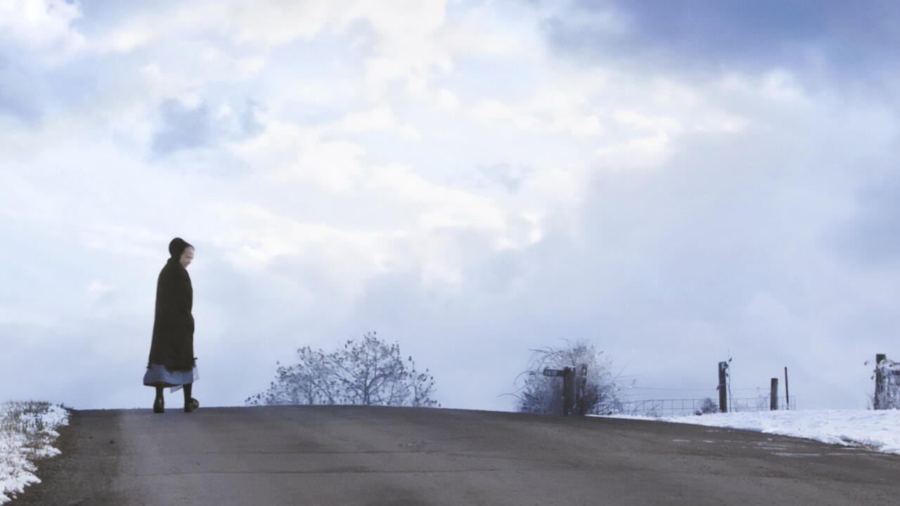 Person walking across snowy road