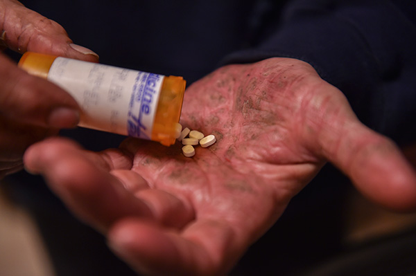 A bottle of pills in a person's hand