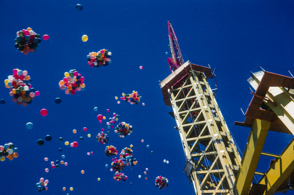 Photographer George Gulacsik took this image of balloons floating above the Space Needle, mid-construction, in July 1961, only a few months after workers began building the structure. Gulacsik's images are now online through the Seattle Public Library.