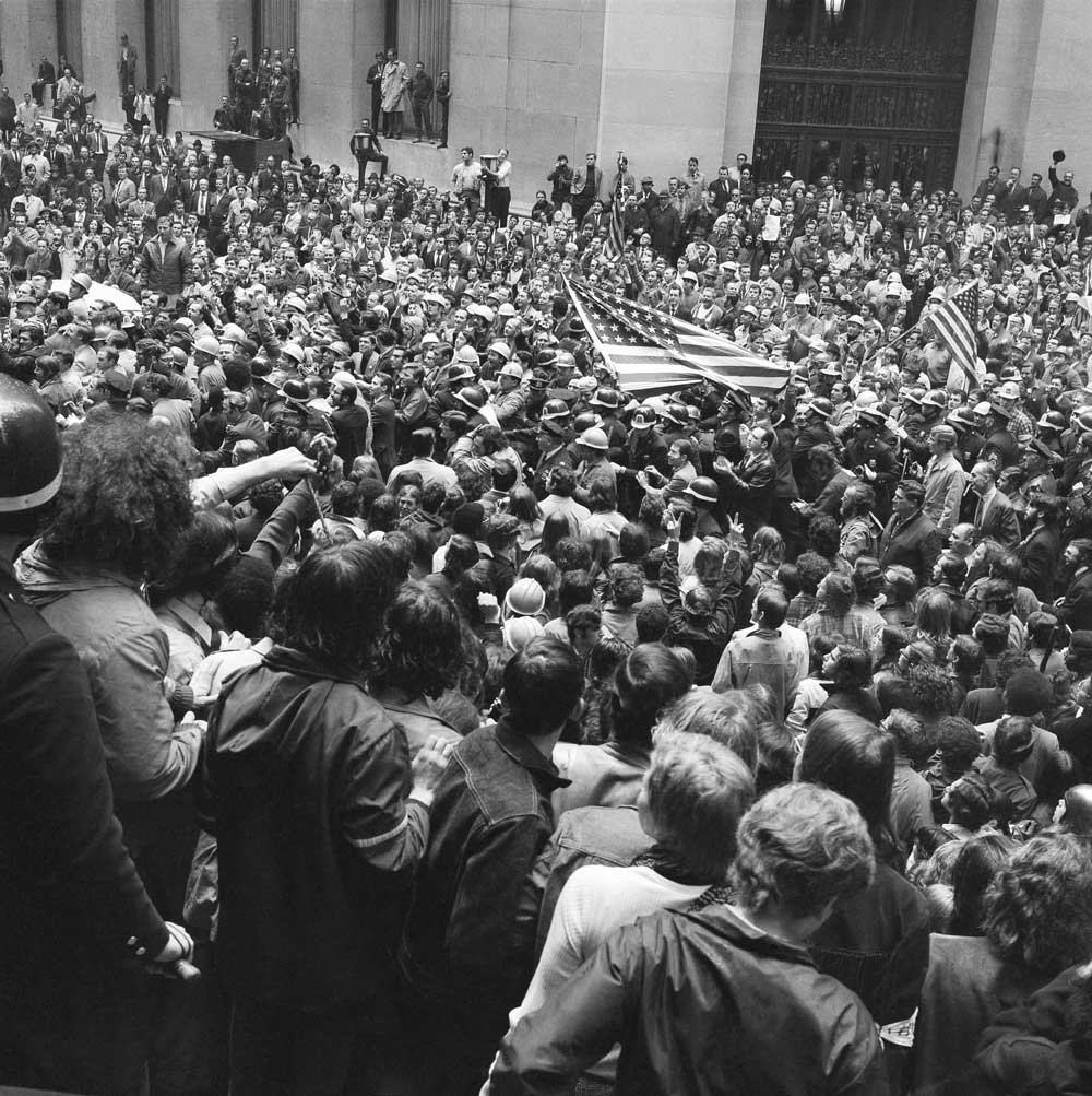 A group of construction workers carrying American flags force their way into a group of antiwar demonstrators gathered in front of the New York Stock Exchange building in Manhattan, May 8, 1970. AP Photo/Ed Ford. Watchf_AP_A_NY_USA_APHS299943_Hardhat_Riots_1970_7005080226.jpg