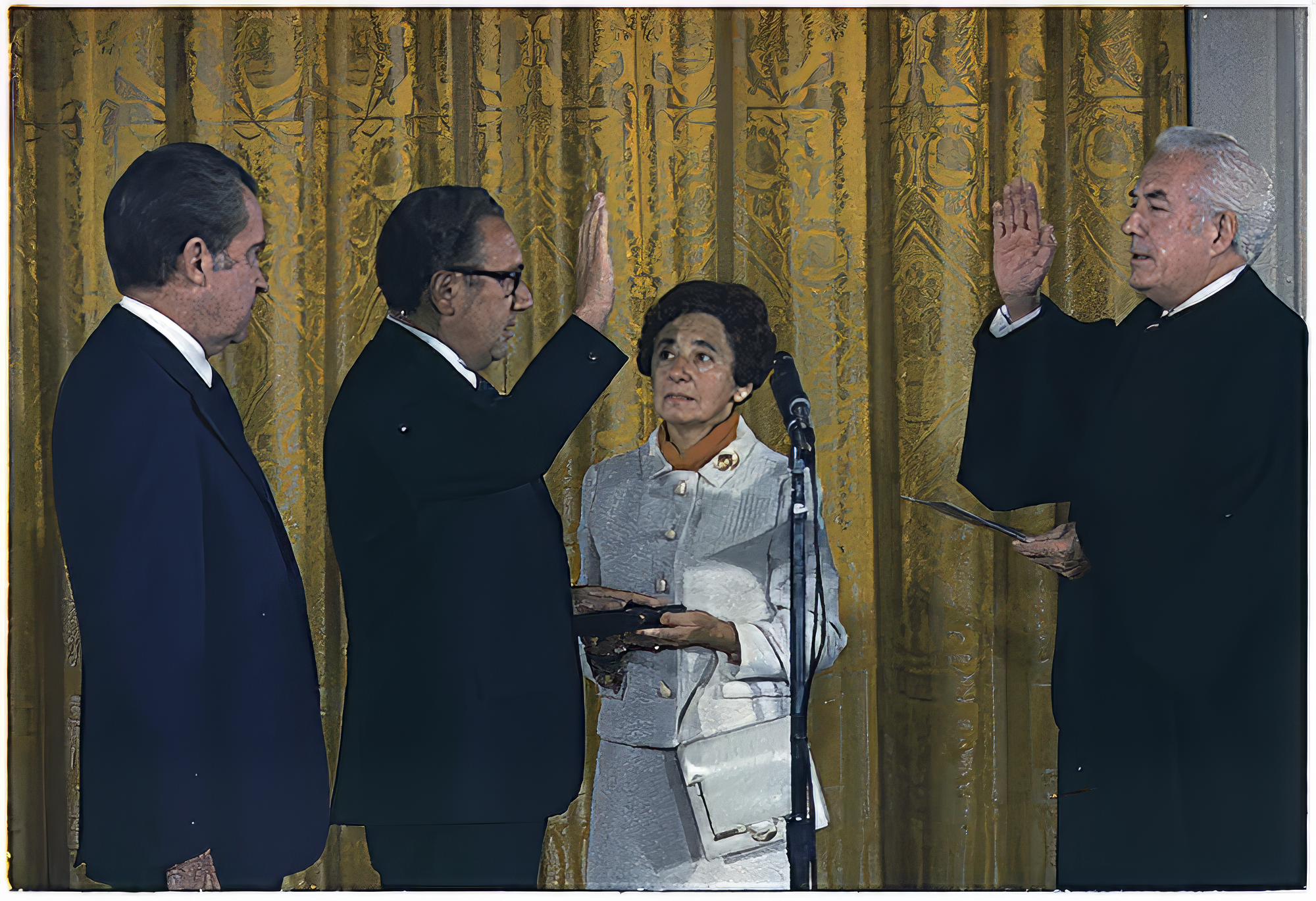 Henry Kissinger being sworn in as Secretary of State, September 22, 1973. Left to right: President Richard M. Nixon, Henry Kissinger, Paula Kissinger, Chief Justice of the Supreme Court Warren Burger. (National Archives) Kissinger swearing in.png