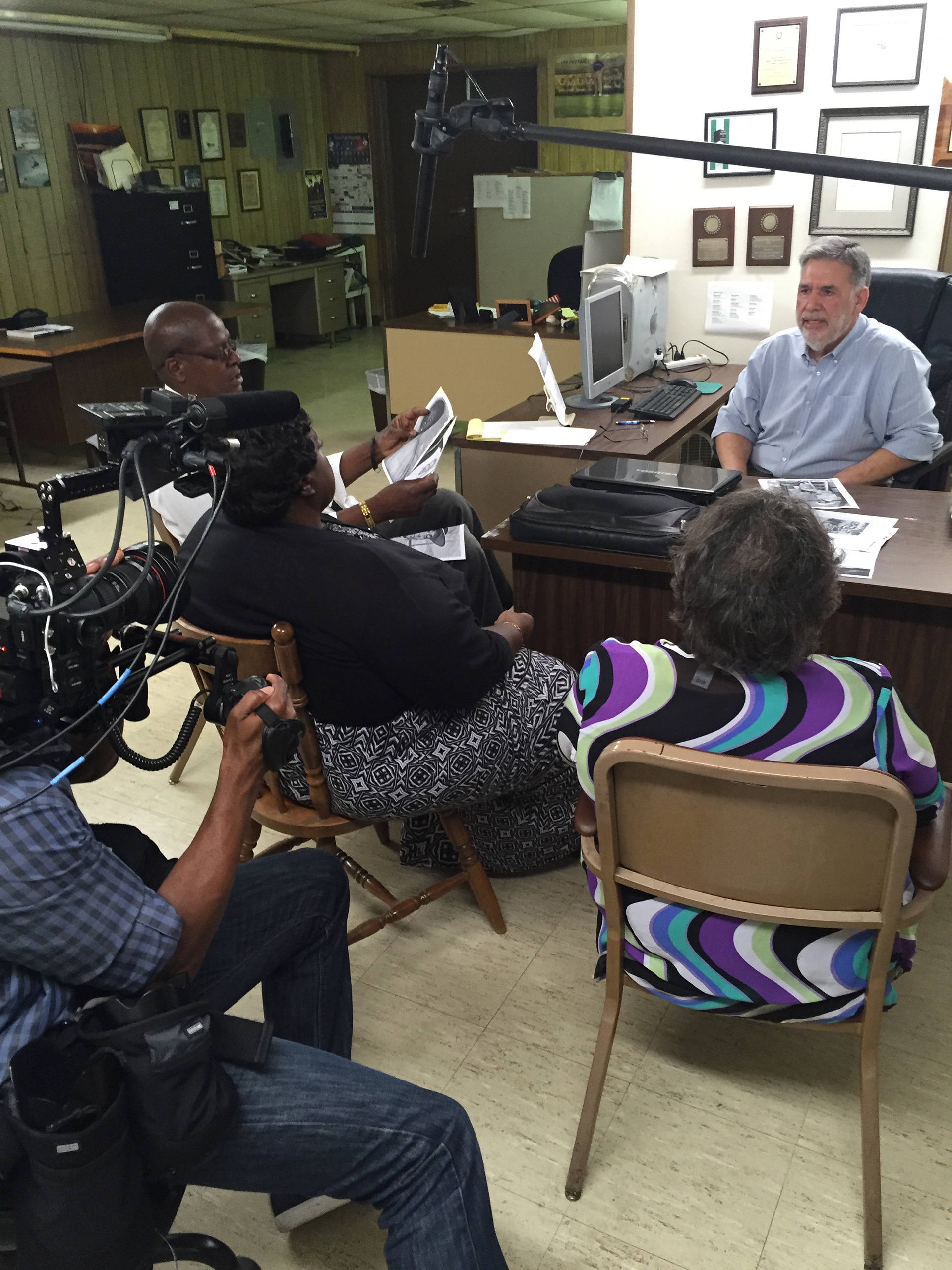 Director of photography Keith Walker films as Wharlest Jackson Jr., Debra Jackson Sylvester and Denise Jackson Ford meet with Stanley Nelson of the Concordia Sentinel during production of "American Reckoning."