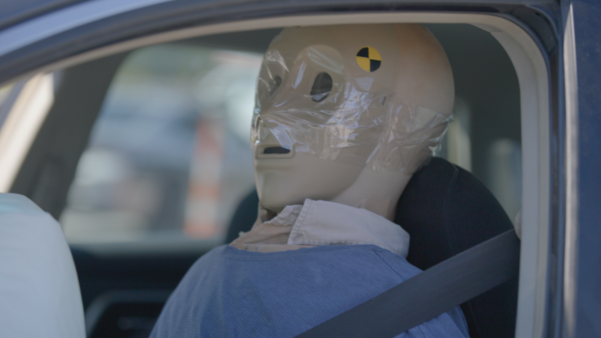 A crash test dummy strapped into a car.