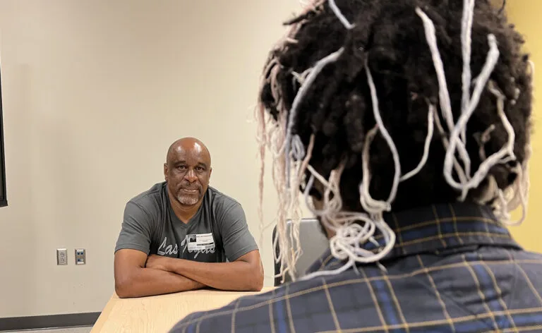 The back of John's head as he sits across the table from his stepfather, Eric Witherspoon.