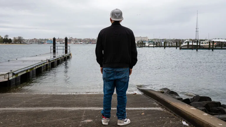 Rodrigo stands at a waterfront.