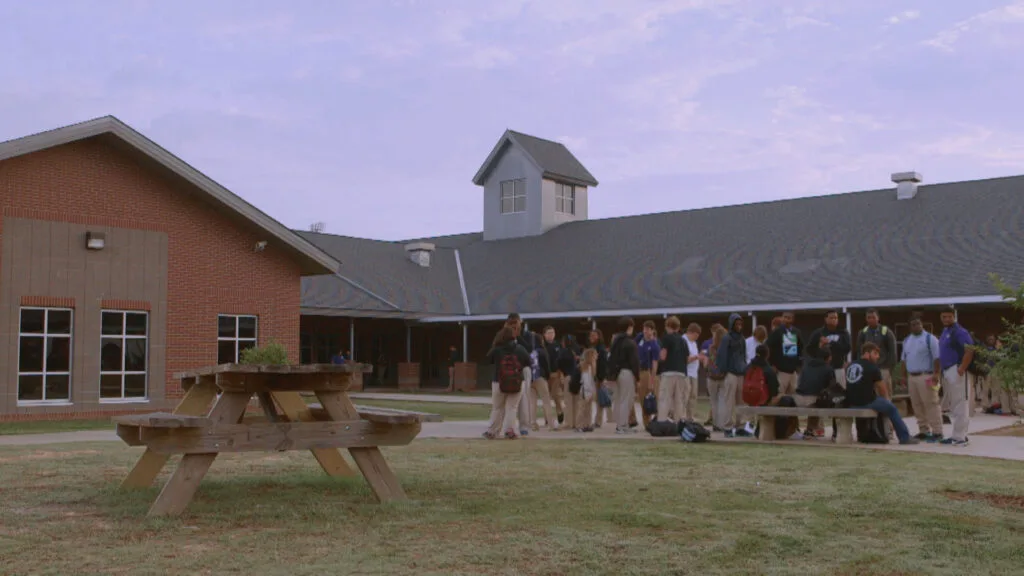 A schoolyard with a large group of students dressed in khaki pants.