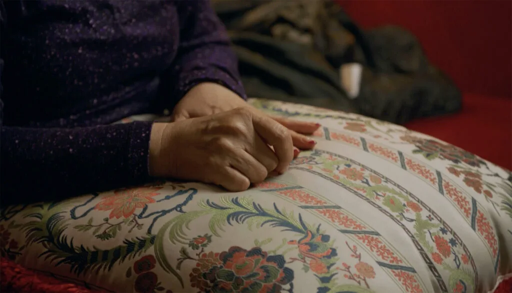 A woman's hands clasped on a pillow.