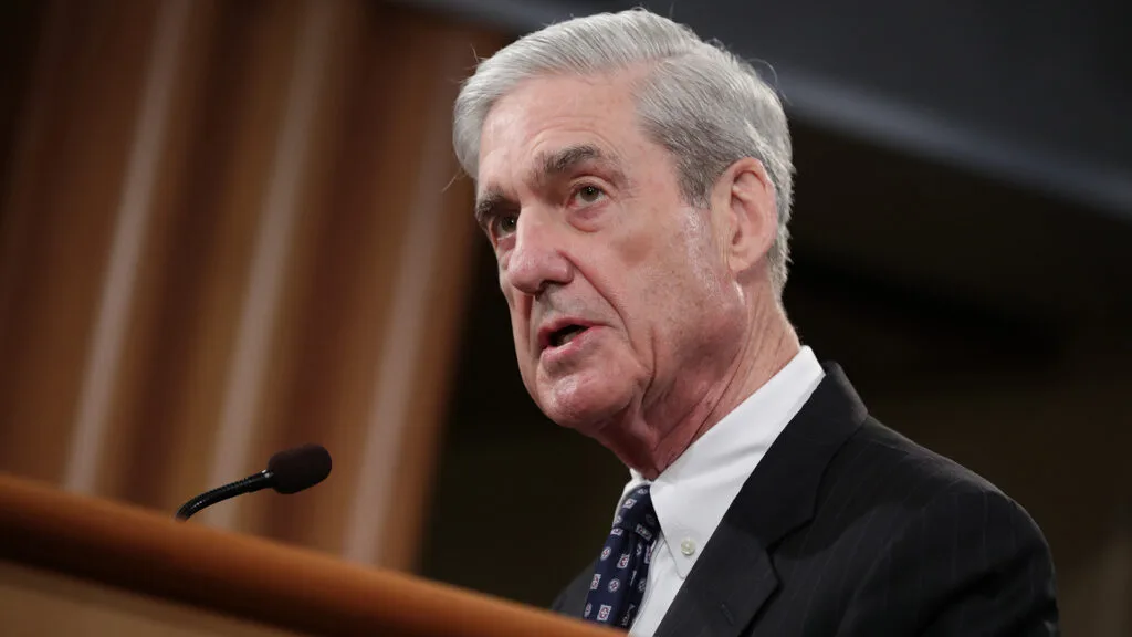 Robert Mueller standing at a podium in front of a microphone.