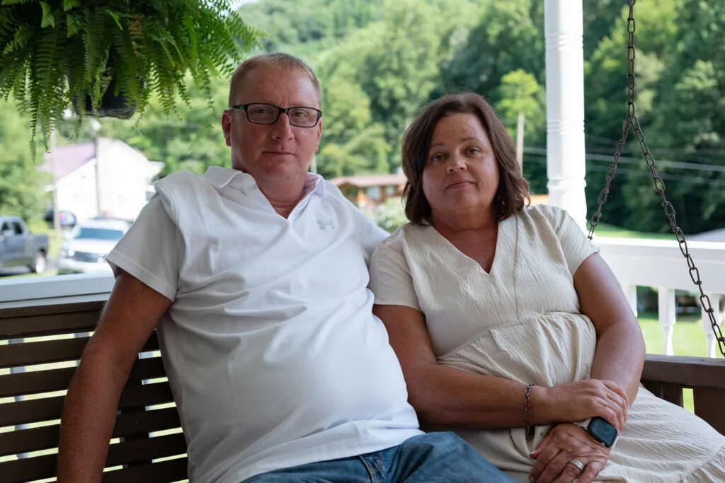 Tim Balthis and Frances (Fran) sit on a swing.