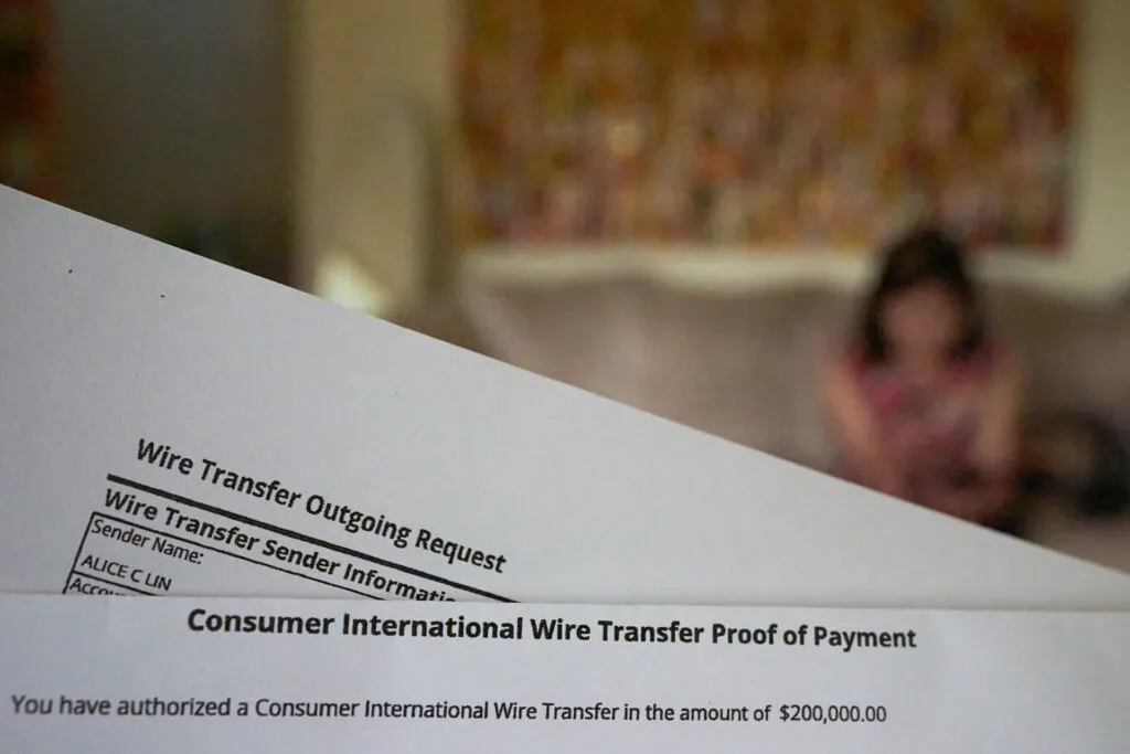 Two documents that say, "Wire transfer outgoing request" and "Consumer international wire transfer proof of payment." A figure is seen out of focus in the background.