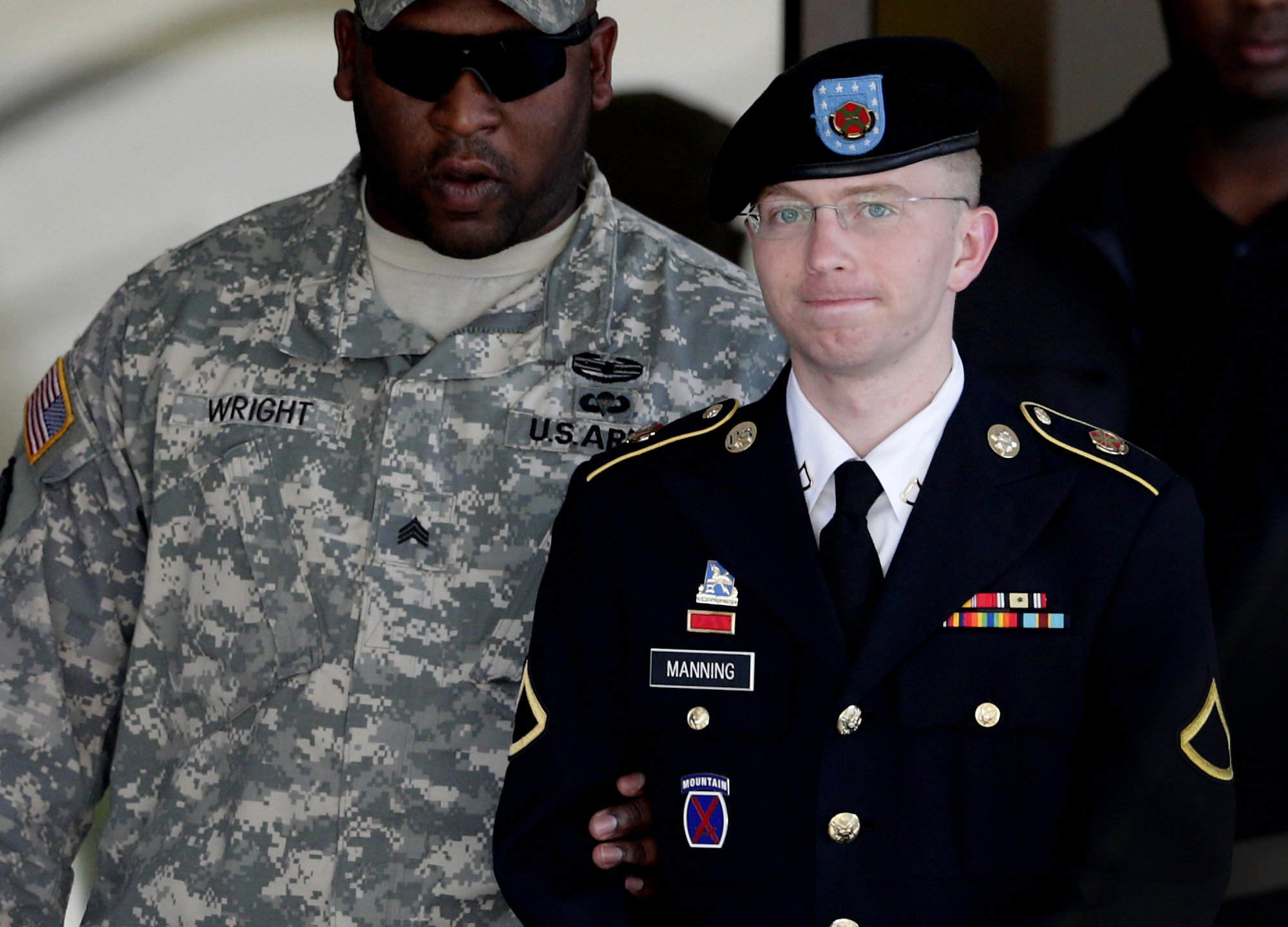 In this June 25, 2012 file photo, Army Pfc. Bradley Manning, right, is escorted out of a courthouse in Fort Meade, Md. Lawyers for Julian Assange argue before the U.S. military’s highest court for public access to legal documents in the court-martial of Pfc. Bradley Manning, the soldier charged with aiding the enemy for allegedly giving hundreds of thousands of classified U.S. documents to Assange’s secret-busting website WikiLeaks.