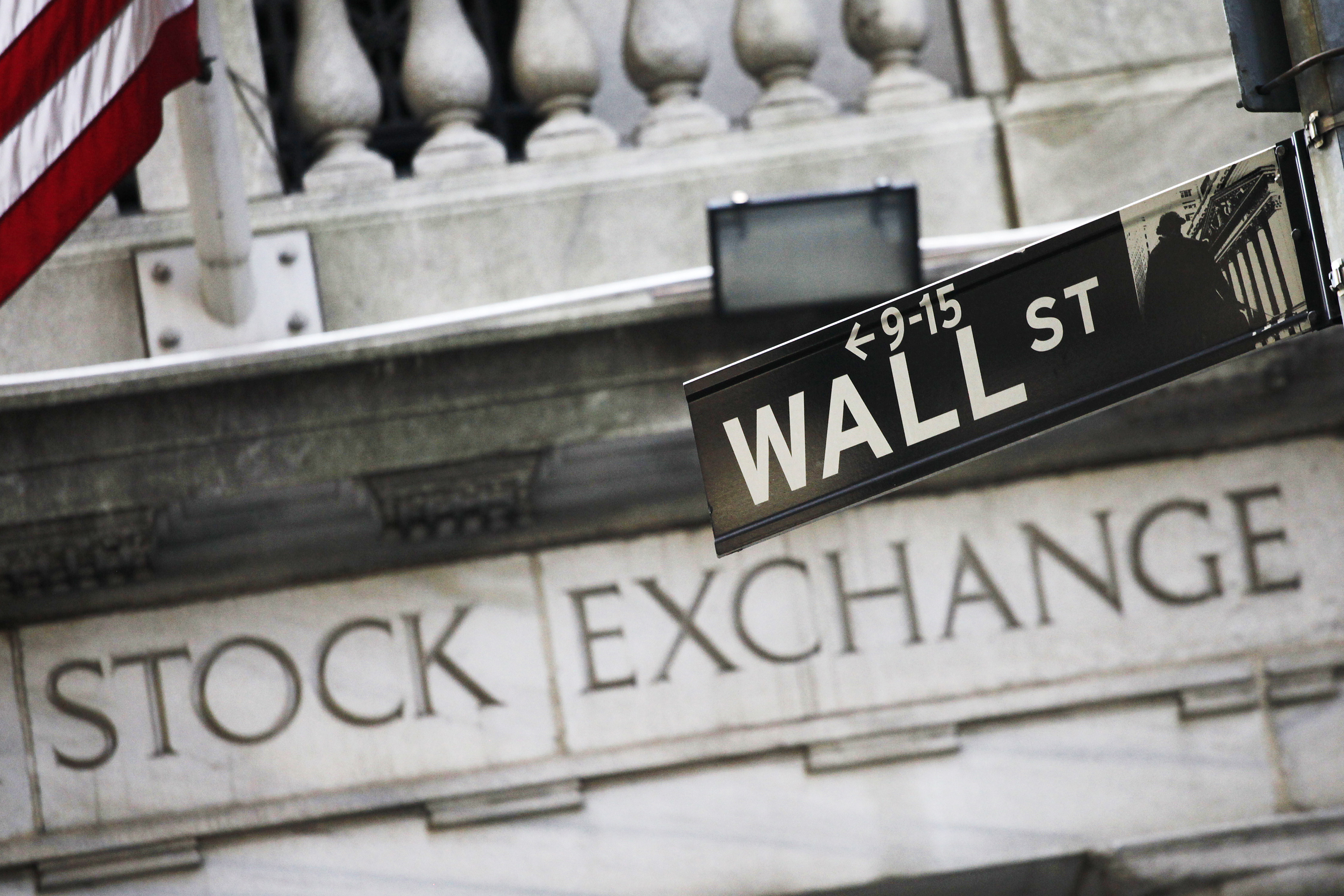 The American flag and a sign for Wall St. are shown outside the New York Stock Exchange, Monday, July 15, 2013 in New York. The stock market took a pause Monday after a scorching start to July.