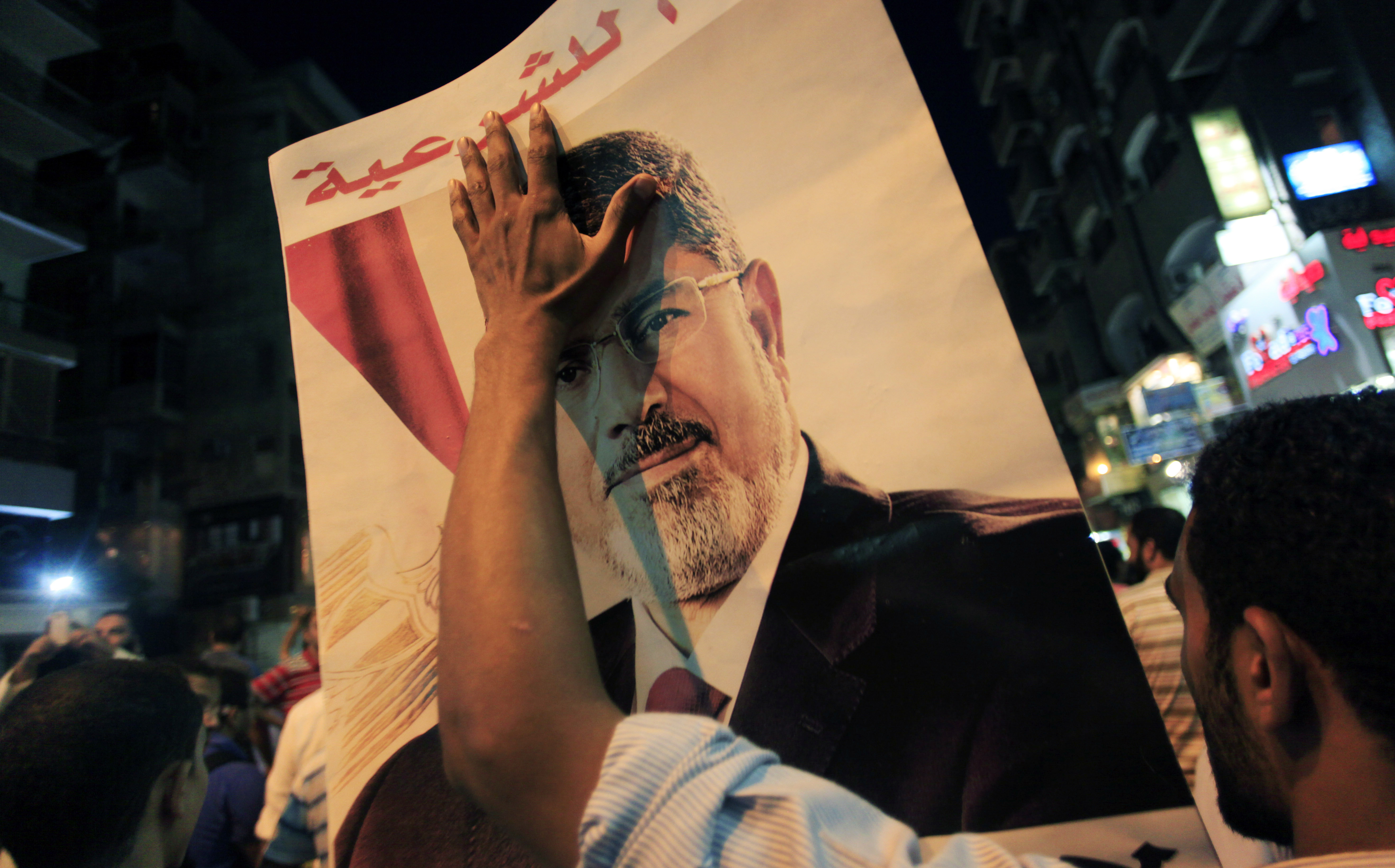 A supporter of Egypt's ousted President Mohammed Morsi, holds a [pster with his picture to commemorate two months since he was ousted, in Cairo, Egypt, Tuesday, Sept. 3, 2013. Egypt's new military-backed government has moved on multiple fronts to put down Morsi supporters, who continue to challenge the popularly supported military coup that removed the country's first elected president. Hundreds of supporters, including leading members of the Muslim Brotherhood and its allies, have been detained or face prosecution on charges ranging from inciting violence to possession of weapons and murder. (AP Photo/Khalil Hamra)