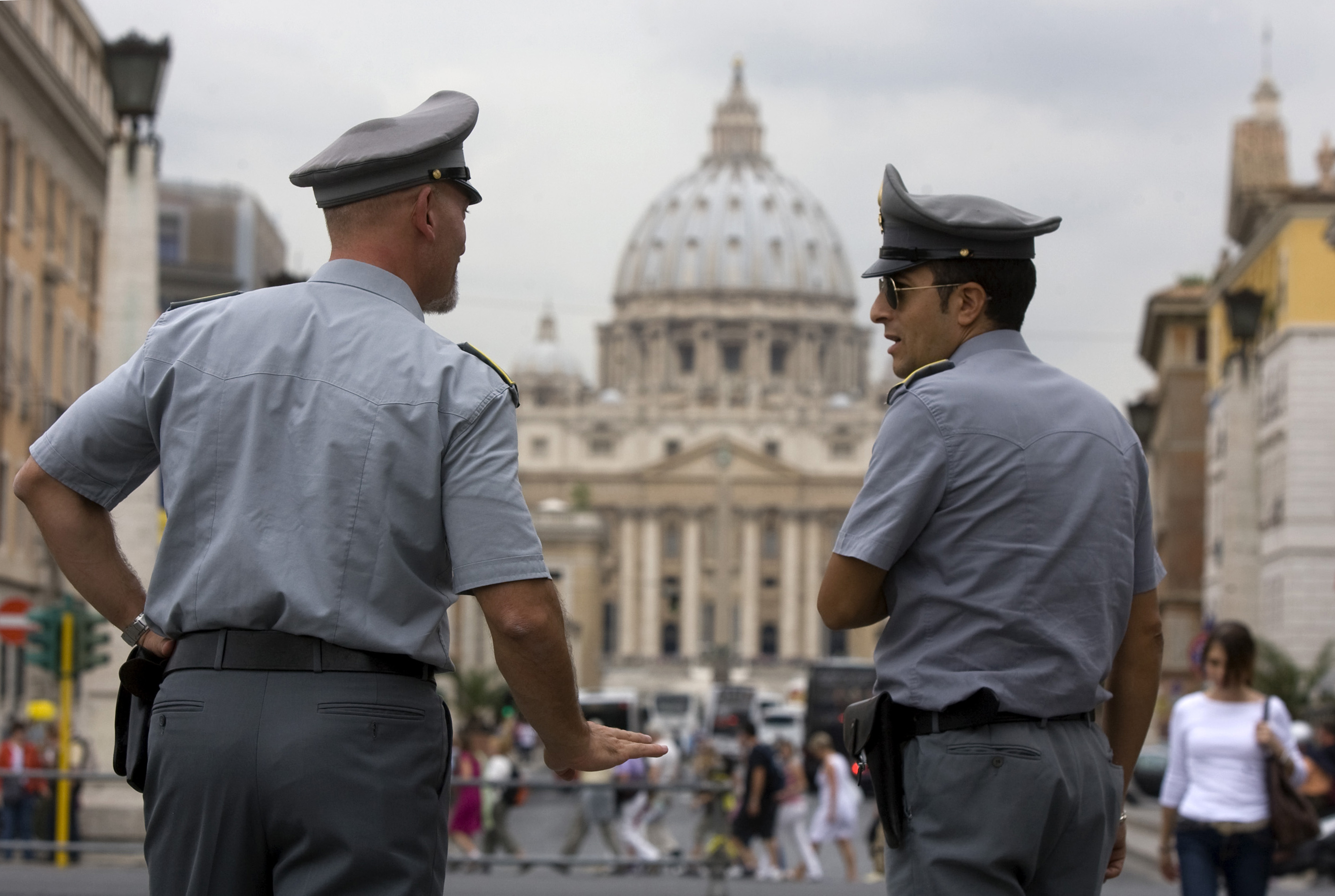 This Sept. 21, 2010 file photo shows Italian financial Police officers talking to each with St. Peter's Basilica at the Vatican in the background, in Rome. On Thursday, Dec. 30, 2010 the Vatican created a new financial watchdog agency and issued new laws to comply with international rules fighting money laundering and terrorist financing. The decrees were passed as Vatican's own bank remains implicated in a money-laundering investigation that resulted in €23 million ($31 million) being seized and its top two officials under investigation.