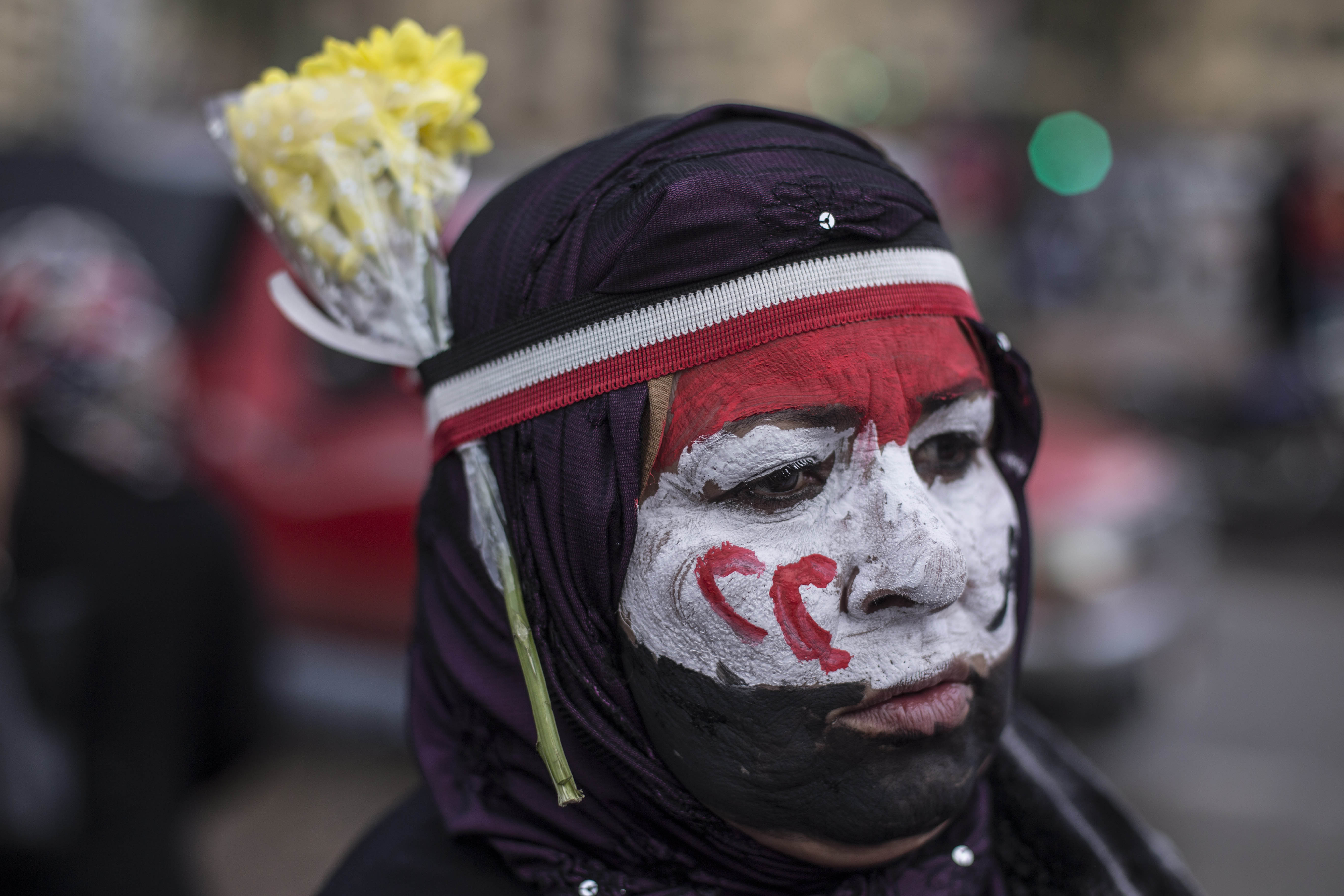 A supporter of President Abdel Fattah El-Sisi paints the flag of Egypt and the first initials of President El-Sisi on her face in Tahrir Square while celebrating the fifth anniversary of the 2011 revolution.