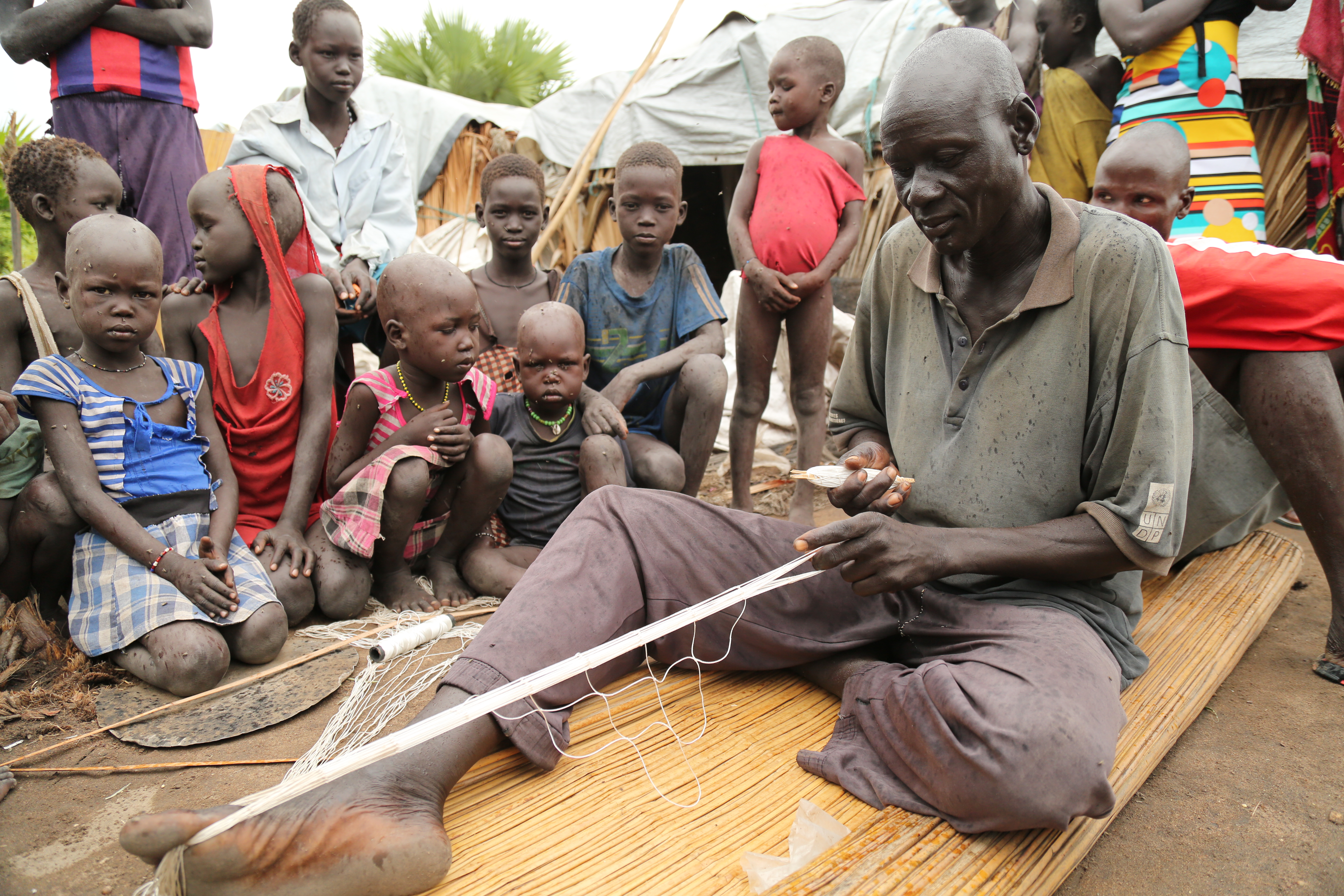 Peter Luak weaves a fishing net to help feed his family. (Photo: Marcelle Hopkins)