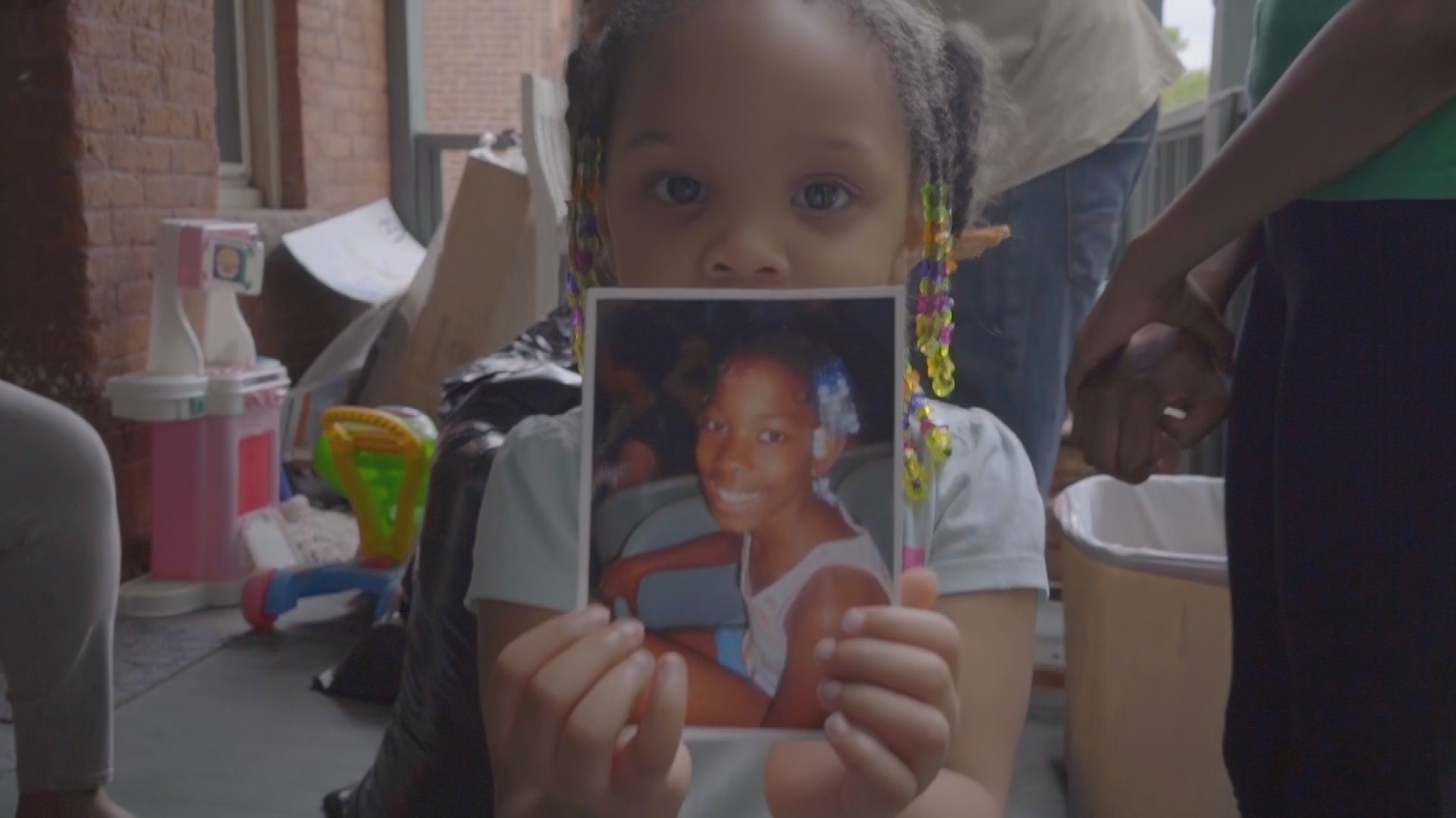 Tearah's little sister holding a photo of Tearah.