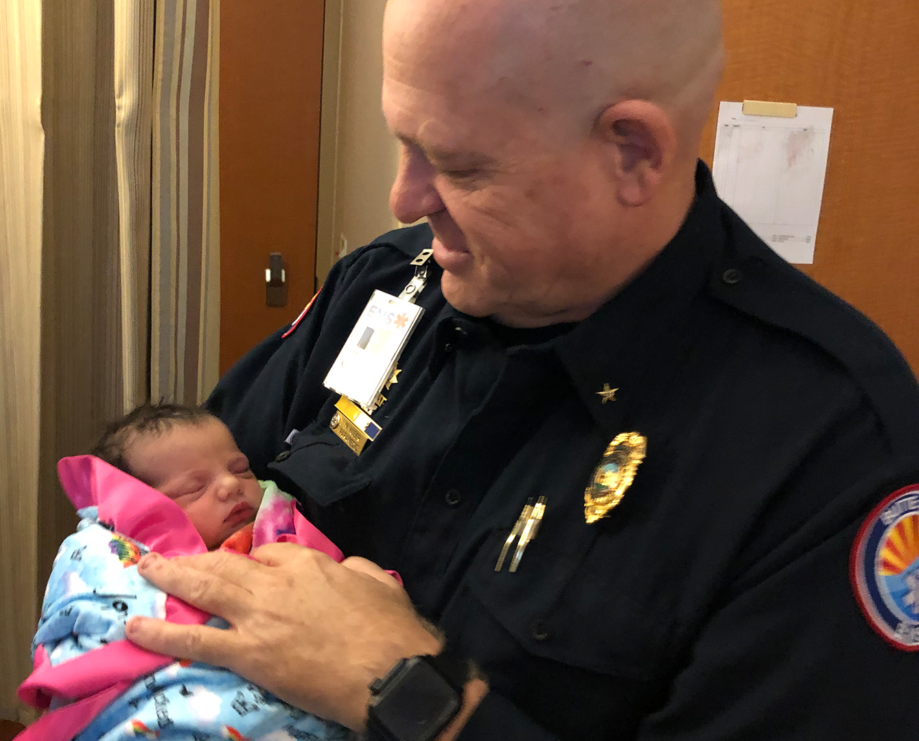 Paramedic Mickey Huber of California holds newborn baby whose mom he rescued in Camp Fire