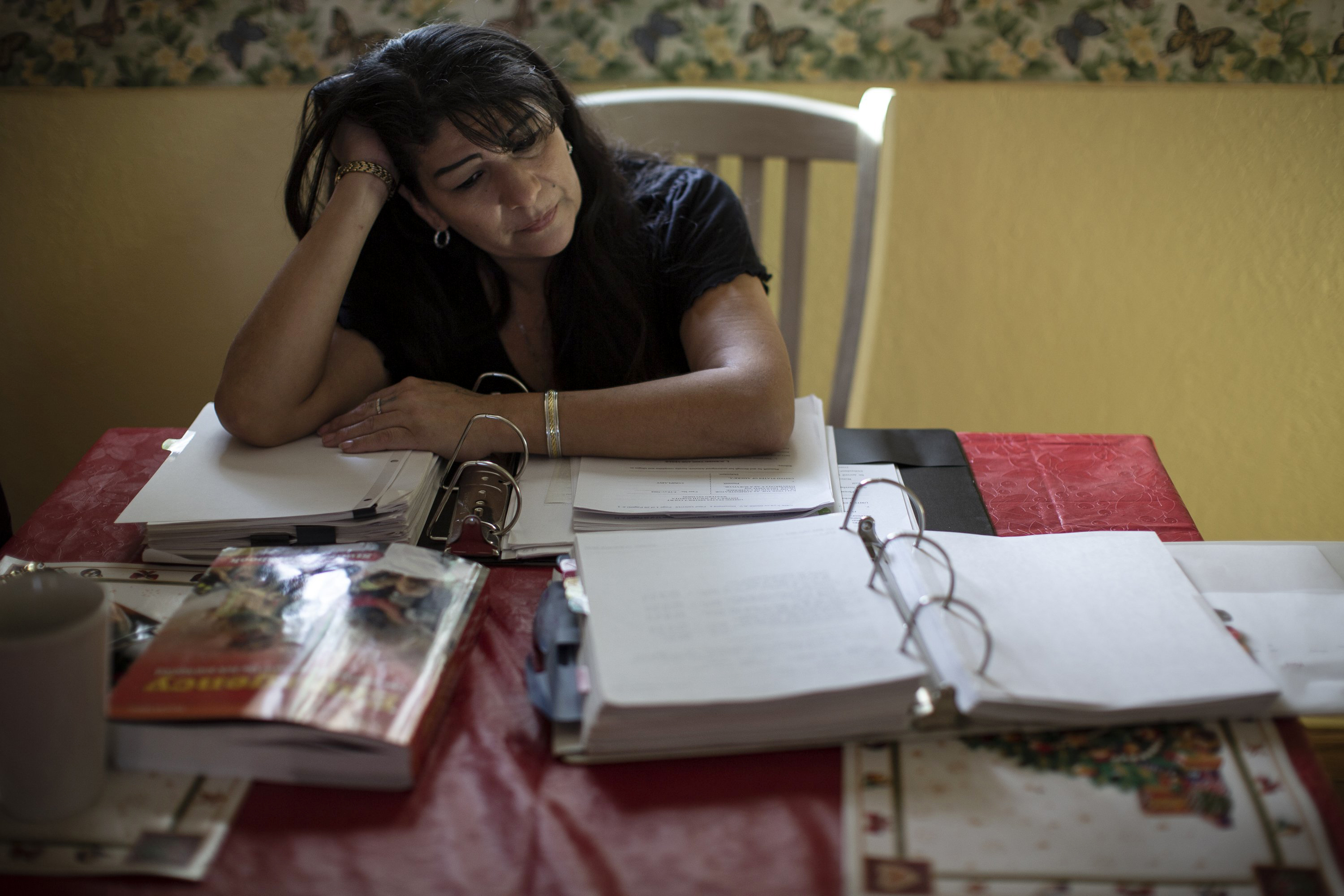 Kali Tree Top, Ms. Miner's daughter, combs through her mother's medical records at her home in Eagle Butte.