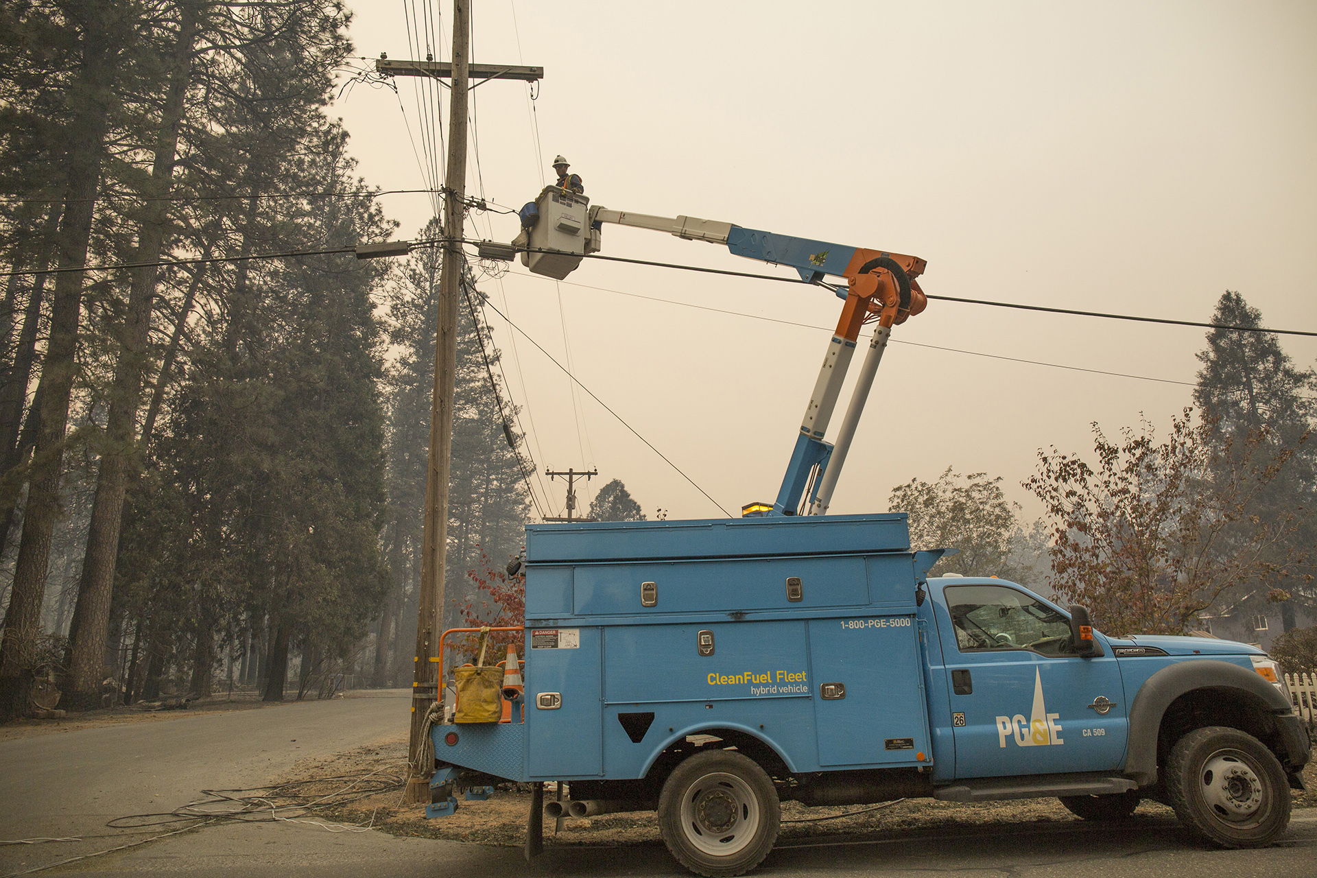 A PG&E worker prepares to cut damaged power lines near Paradise, Calif. on Nov. 13, 2018, five days after a PG&E transmission line sparked the Camp Fire, the deadliest and most destructive wildfire in modern California history. The blaze leveled the town of Paradise and killed 85 people.