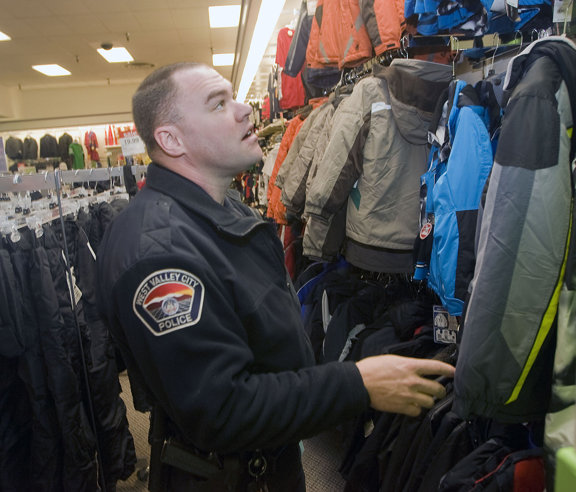 (Al Hartmann  |  The Salt Lake Tribune)  West Valley City police officer Tyler Longman shops for a 14-year-old boys coat at JC Penney at the Valley Fair Mall in Dec. 2010.
