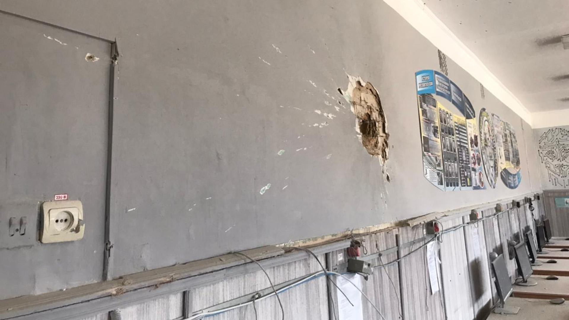 A gray interior school wall is marked by a large hole in Kukhari, Ukraine.