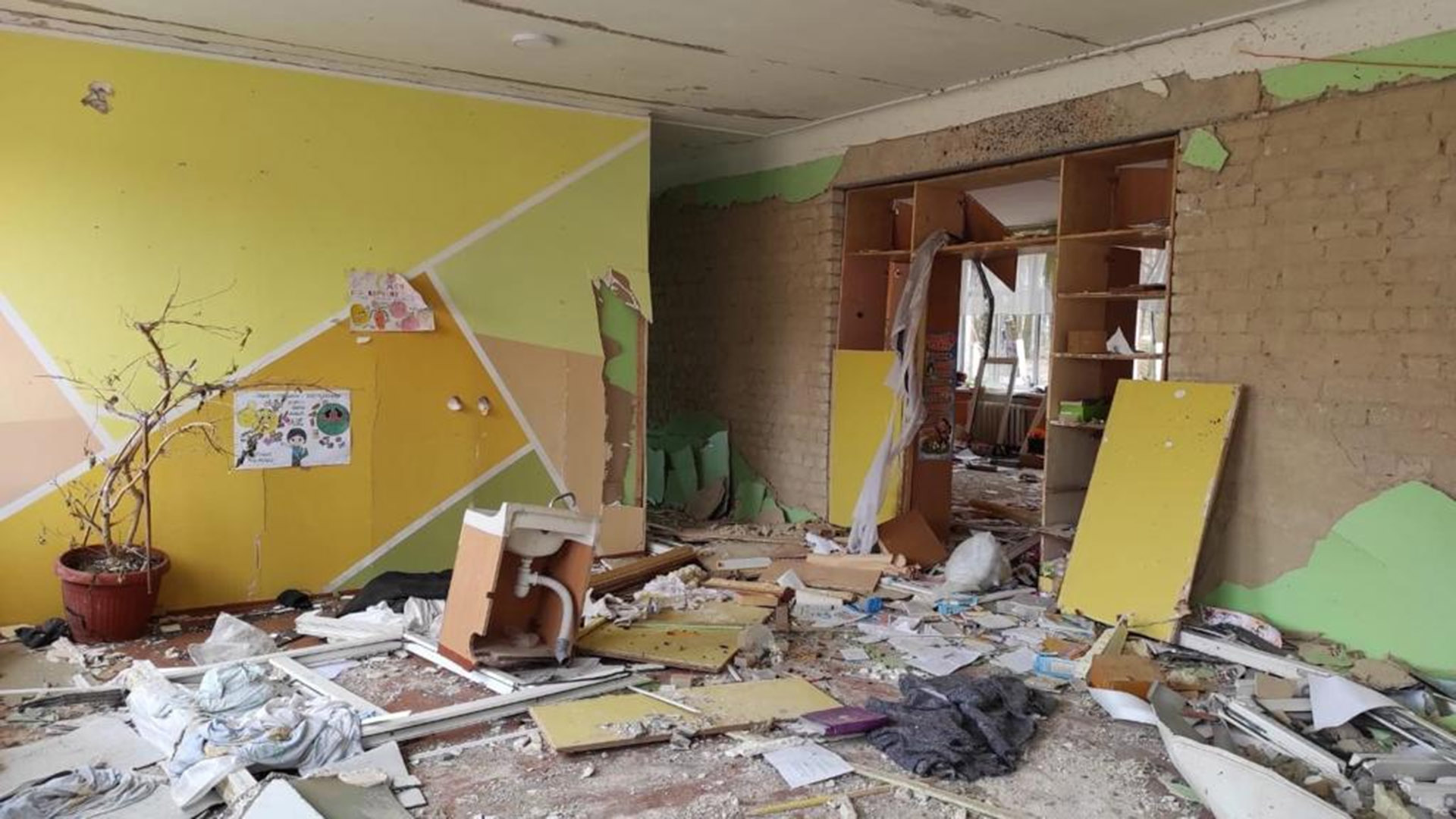 A school room lies in disrepair, with rubble strewn across the floor.