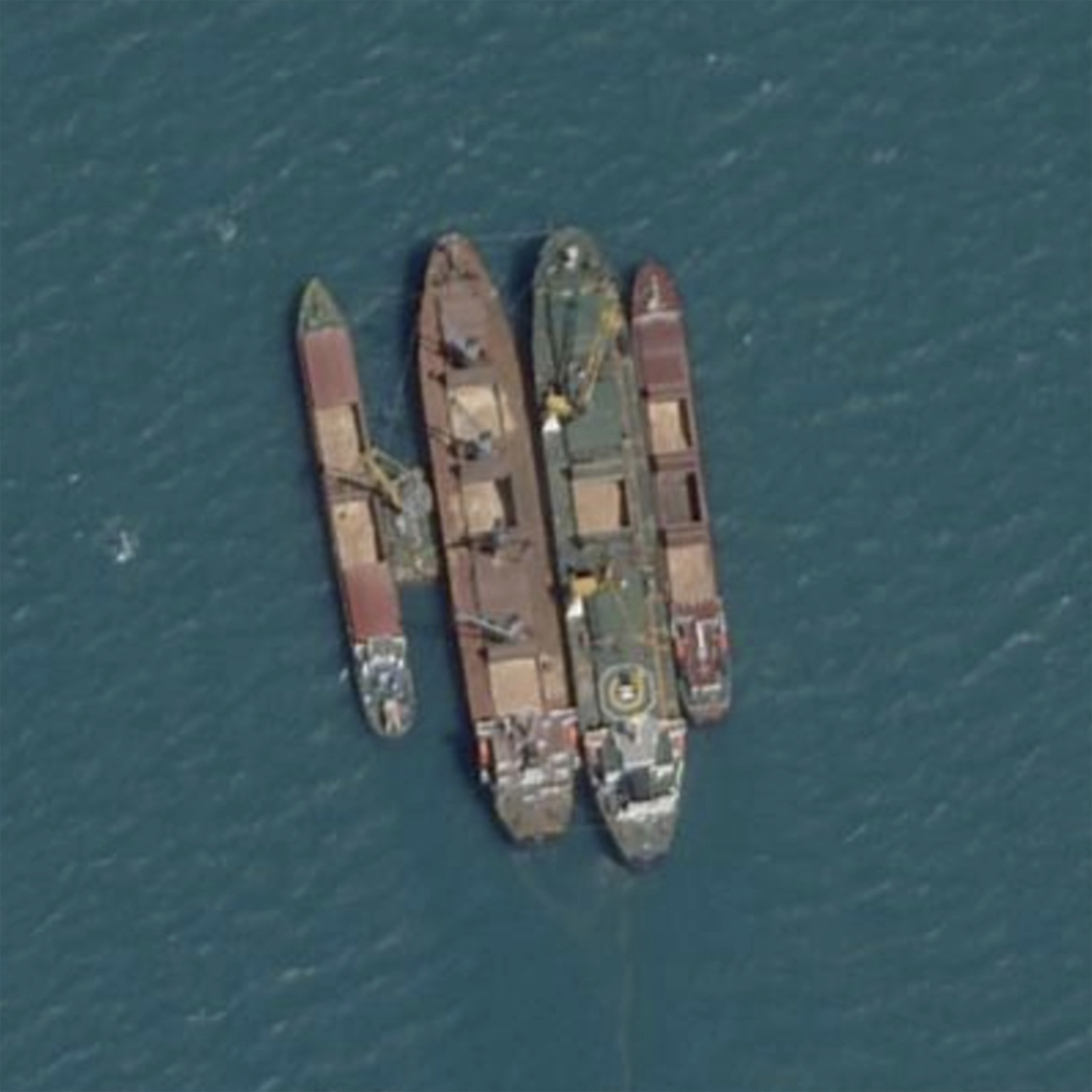 This Planet Labs satellite image shows a ship-to-ship transfer in the Kerch Strait, between Crimea and Russia, on July 18, 2022. Satellite imagery and transponder data reviewed by The Associated Press shows numerous large cargo ships anchored off the Russian coast rendezvousing with smaller ships shuttling grain from both occupied Ukrainian ports in Crimea and Russian ports, obscuring the true origin of the cargo. Those larger ships then carried the blended grain to ports in Egypt, Libya, Iraq and Saudi Arabia. (Planet Labs via AP)