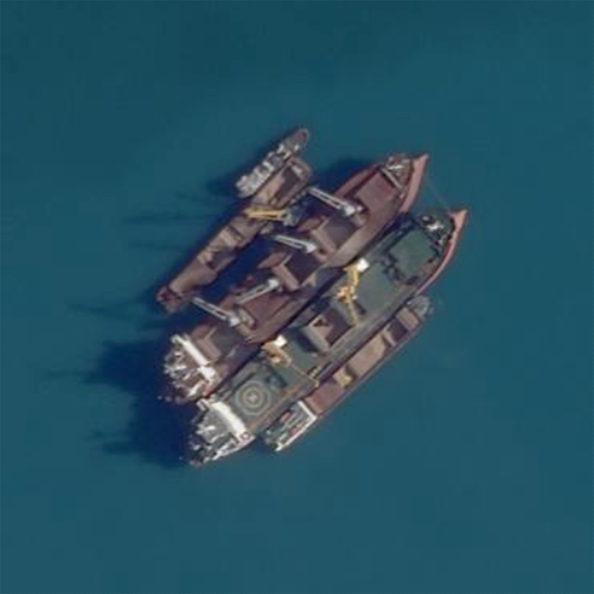 This Planet Labs satellite image shows a ship-to-ship transfer in the Kerch Strait, between Crimea and Russia, on Sept. 16, 2022. Satellite imagery and transponder data reviewed by The Associated Press shows numerous large cargo ships anchored off the Russian coast rendezvousing with smaller ships shuttling grain from both occupied Ukrainian ports in Crimea and Russian ports, obscuring the true origin of the cargo. Those larger ships then carried the blended grain to ports in Egypt, Libya, Iraq and Saudi Arabia. (Planet Labs via AP)
